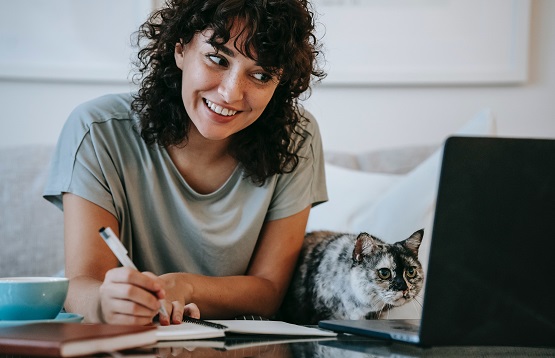 women sitting with cat while working on a laptop